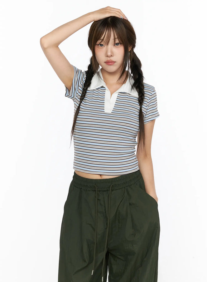 Striped Collared Crop Top Tee CL514 Blue front shot on model with hand raised to head, white polo collar, paired with dark green wide-leg pants
