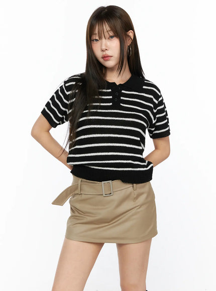 Striped Collared Knit Short Sleeve Top CL514 Black front shot on model hands on hips showing cropped fit black white stripe knit polo with khaki belted skirt
