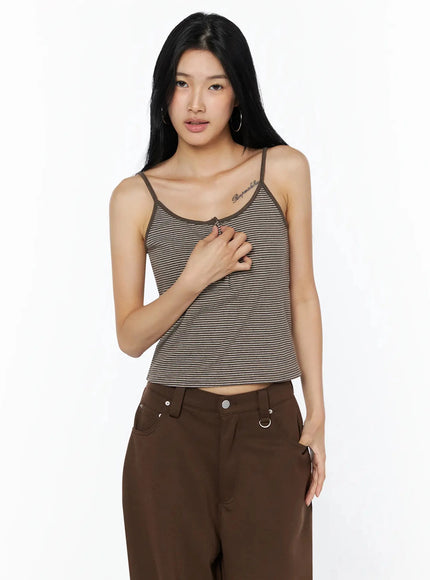 Striped Henley Tank Top IL509 Brown front model shot, hand touching chest near button placket, fitted cropped tank with fine horizontal stripe texture