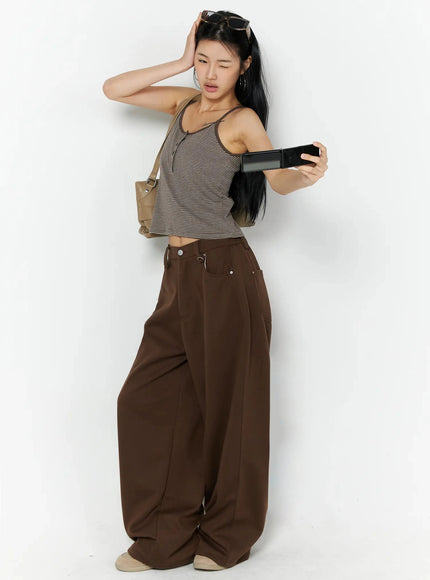 Striped Henley Tank Top IL509 Brown lifestyle side model shot holding phone and bag, sunglasses on head, showing stripe cami and wide-leg trouser outfit