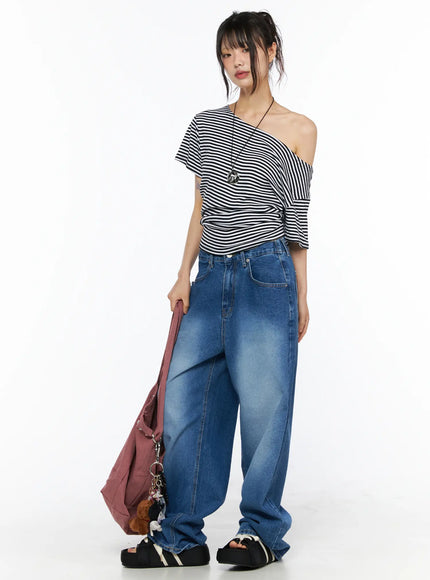 Striped Off-Shoulder Top CU530 Black full-body side shot on model paired with wide-leg jeans, showcasing asymmetric one-shoulder silhouette and relaxed fit
