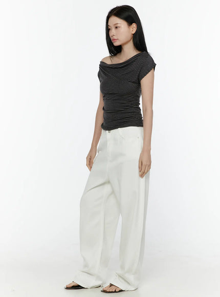 Striped Off-Shoulder Top IL506 Dark gray side model shot showing draped off-shoulder neckline and fitted ruched silhouette with white pants