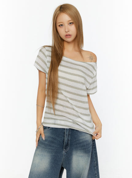 Striped Off-Shoulder Top IL524 Dark blue front shot on model showing asymmetric off-shoulder neckline olive stripe open-knit texture paired with wide-leg jeans