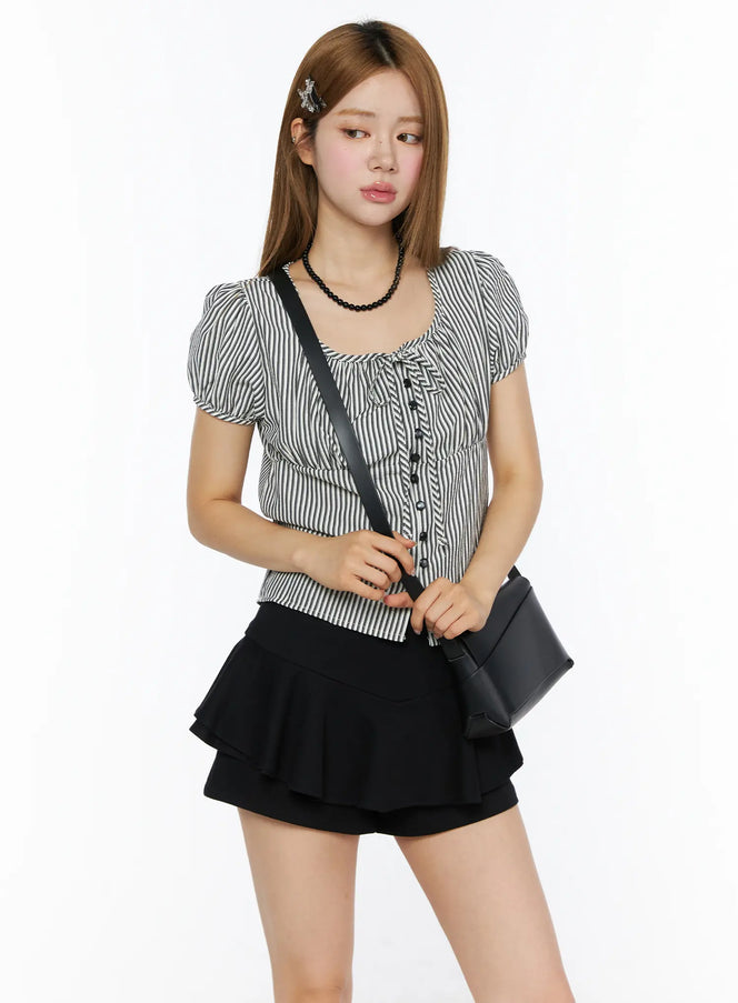 LEWKIN Striped Puff Short Sleeve Blouse CL502 Black three-quarter front shot on model with puff sleeves, tie neckline, button-front, styled with black crossbody bag