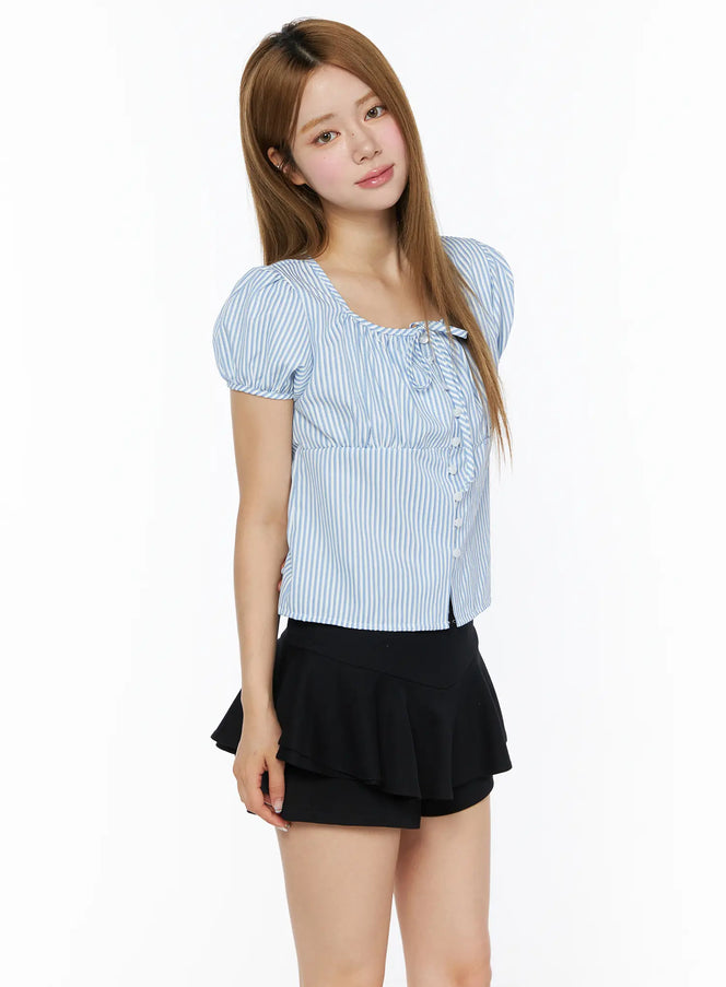 Striped Puff Short Sleeve Blouse CL502 Blue side front shot on model with square neckline, puff sleeves, front button closure, paired with black mini skirt