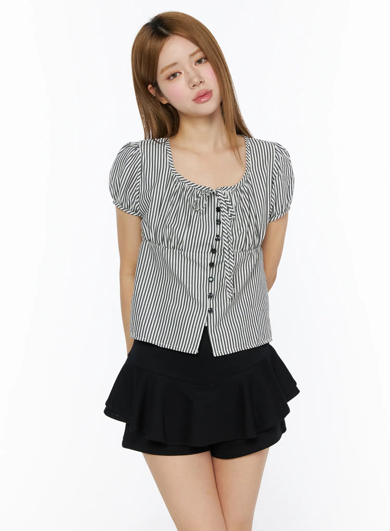 Striped Puff Short Sleeve Blouse CL502 Black three-quarter front shot on model with hands behind back, square neckline tie detail, puff sleeves, button-front, styled with black ruffle mini skirt