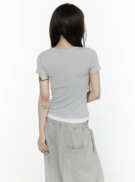 Striped T-Shirt IL522 White back shot on model, fitted striped short-sleeve top revealing clean back seams, cream contrast ribbed hem, styled with gray wide-leg sweatpants