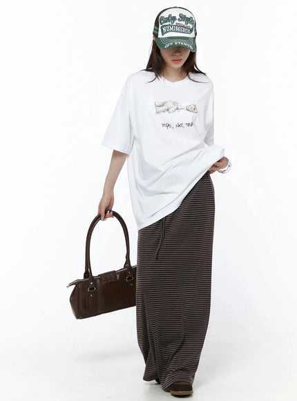 Striped Tie Maxi Skirt IL506 Brown full outfit front view on model with cap and leather bag, showing complete brown stripe maxi skirt styling