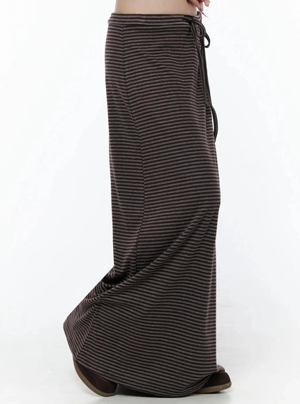 Striped Tie Maxi Skirt IL506 Brown side view on model showing skirt silhouette, drawstring tie at waist, and flared maxi hem detail