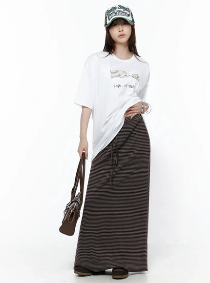 Striped Tie Maxi Skirt IL506 Brown full-length front view on model styled with white graphic tee, cap, and brown leather bag