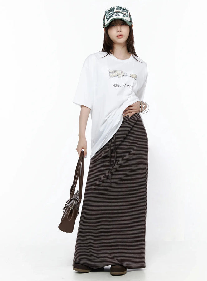 Striped Tie Maxi Skirt IL506 Brown full-length front view on model styled with white graphic tee, cap, and brown leather bag
