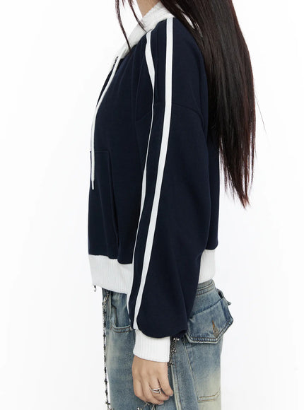 Striped Track Hoodie CL524 Dark blue side detail shot on model, white double stripe running along sleeve length, ribbed white hem and cuff contrast against navy fleece fabric