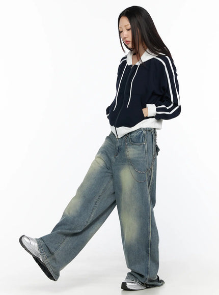 Striped Track Hoodie CL524 Dark blue side shot on walking model looking down, white double sleeve stripes and ribbed hem visible, cropped length above waist