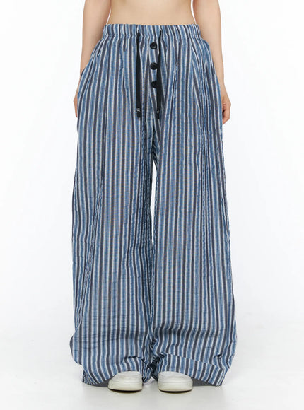 Striped Wide-Leg Trousers CL502 Blue front shot on model showing elastic drawstring waist with three black buttons and wide-leg crinkle stripe silhouette