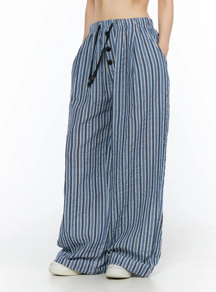 Striped Wide-Leg Trousers CL502 Blue three-quarter front shot on model showing button fly drawstring waist and wide crinkle stripe leg with pooled hem