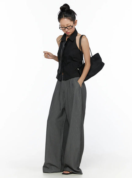 Striped Wide Slacks CL510 gray front three-quarter model shot with model looking down, hands in pocket, paired with black halter top and bag