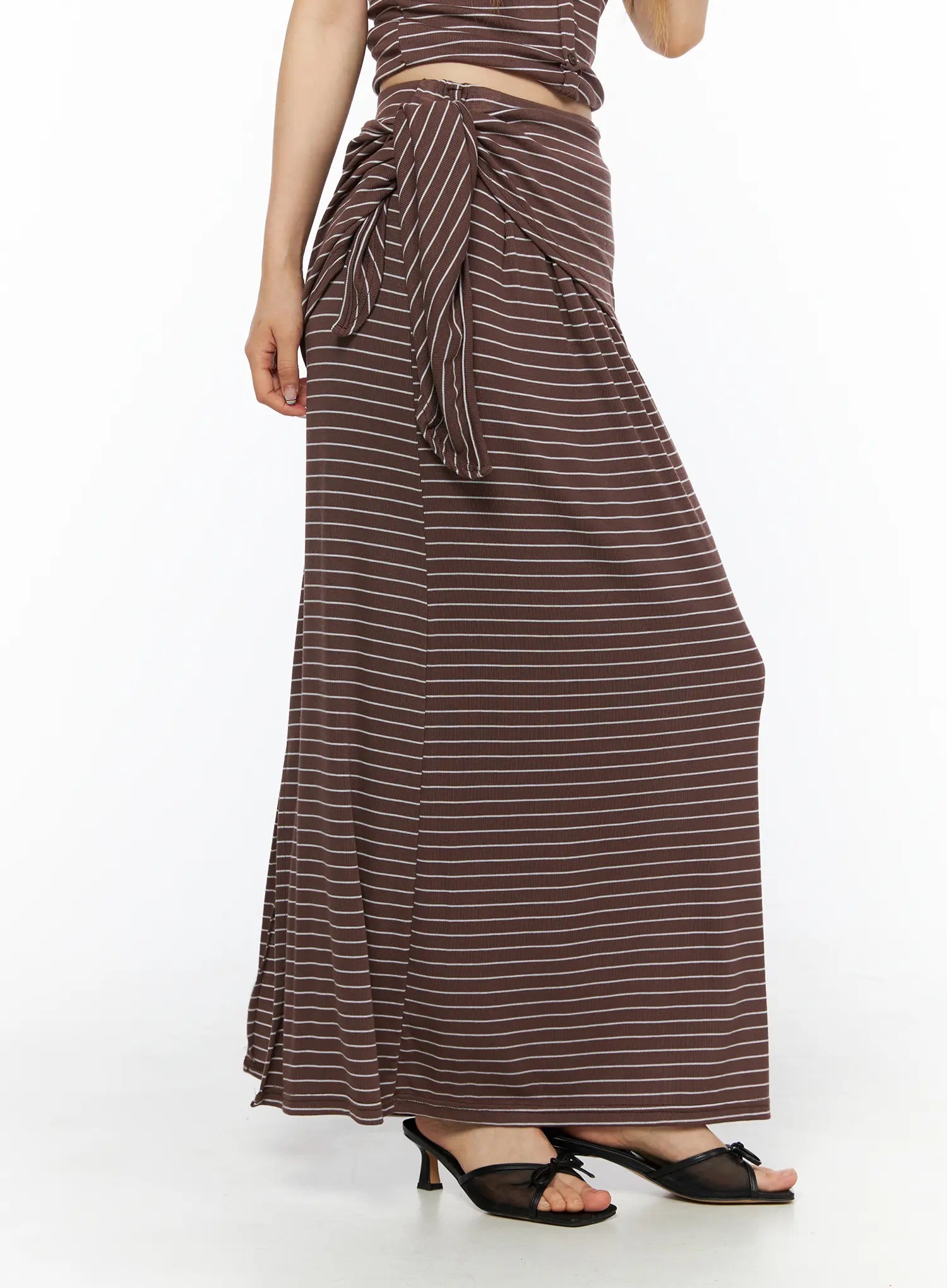 Striped Wrap Maxi Skirt CL502 Brown side view on model showing draped side-tie knot waist detail flared hem and black kitten heel sandals