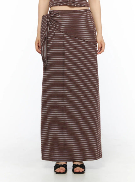 LEWKIN Striped Wrap Maxi Skirt CL502 Brown S/M front view on model cropped at waist showing side-tie knot detail with white stripe ribbed texture and black bow sandals