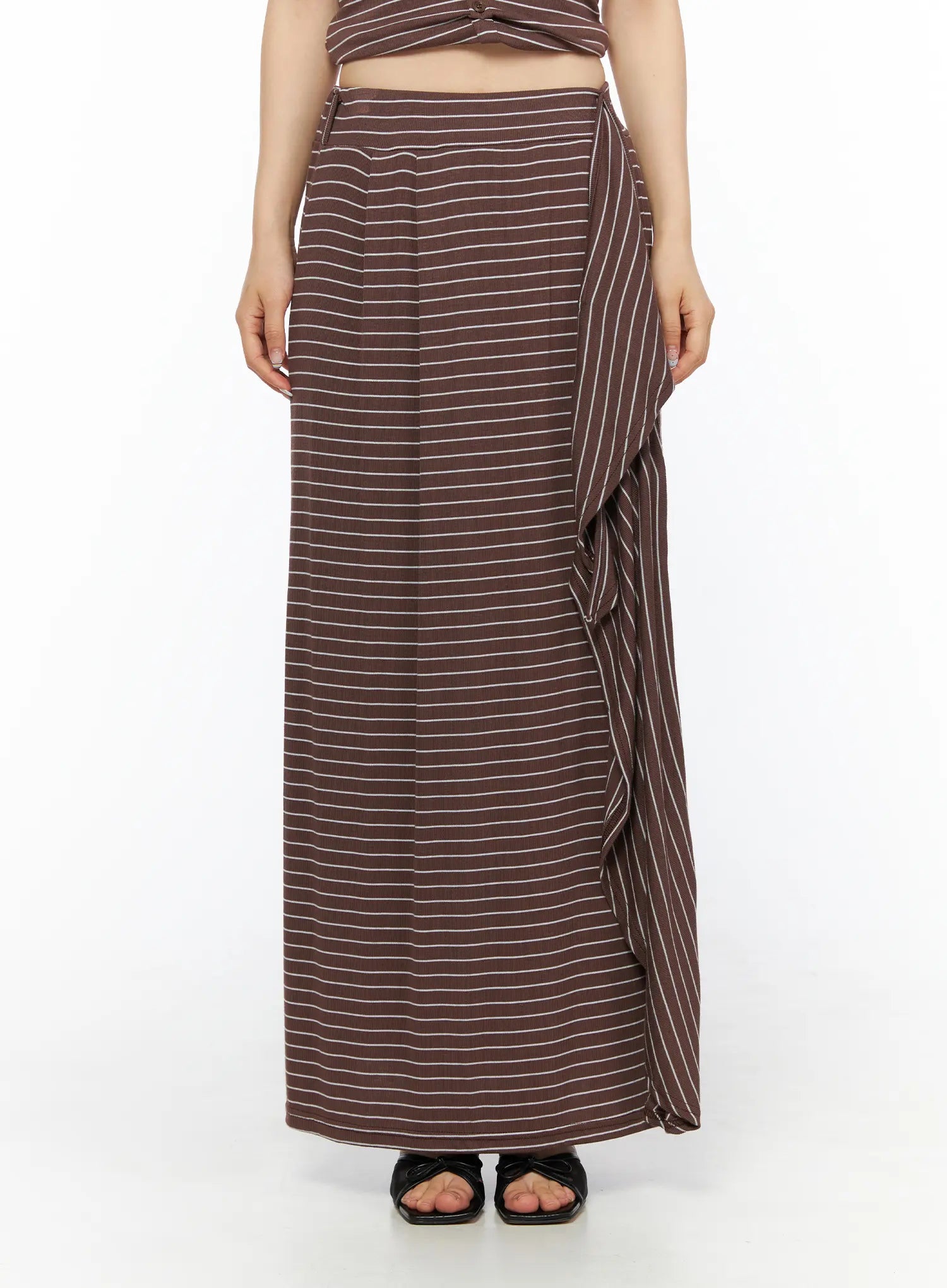 Striped Wrap Maxi Skirt CL502 Brown front close-up view on model showing elasticated waistband side-tie knot center pleat seam and ribbed striped fabric detail