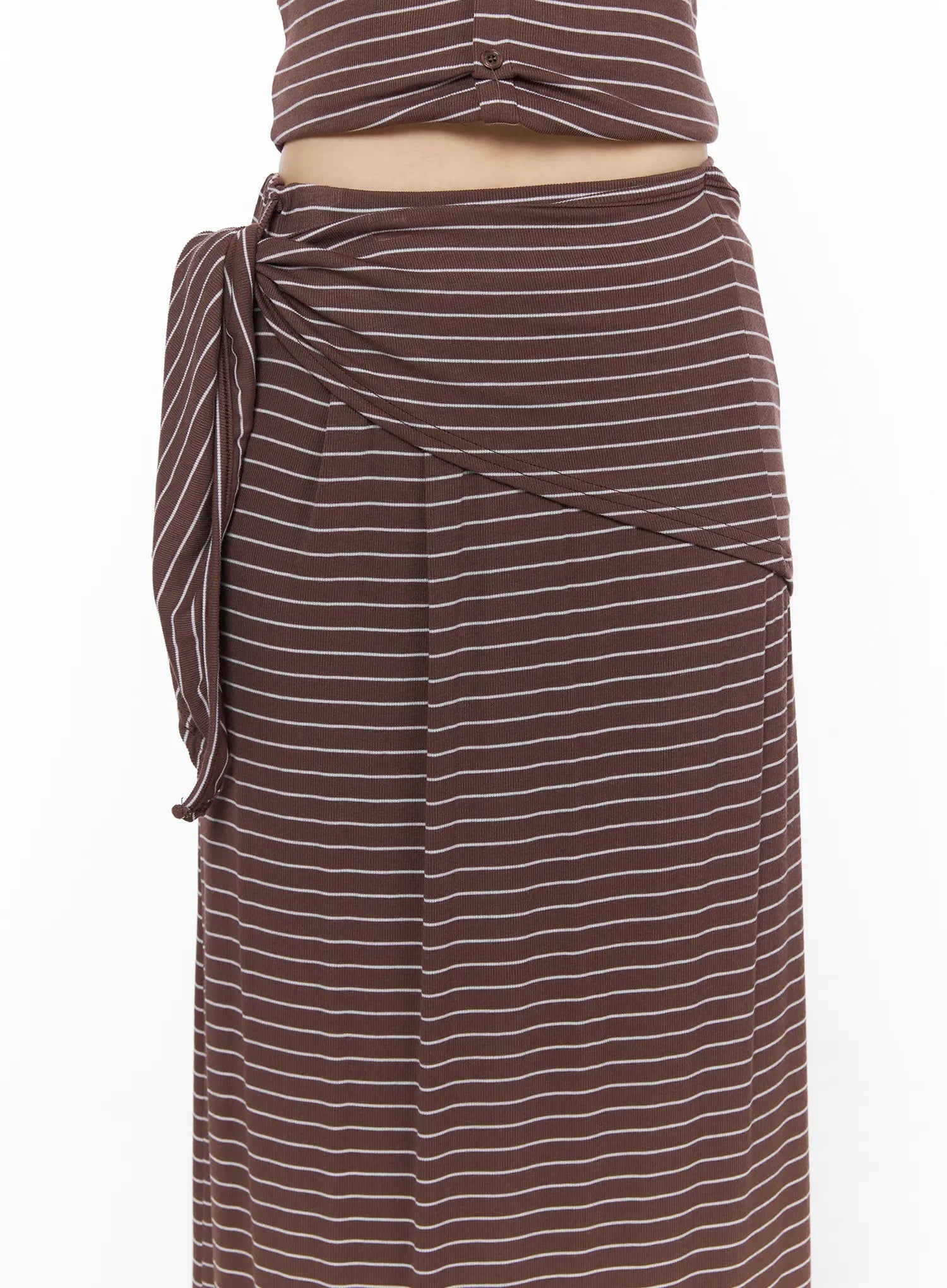 Striped Wrap Maxi Skirt CL502 Brown close-up front detail of side-tie knot waistband wrap drape seam lines and ribbed white stripe fabric texture on model
