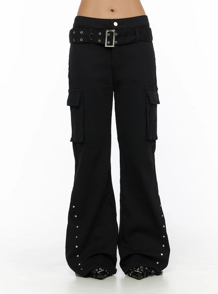 Studded Bootcut Pants CL503 Black front close-up on model showing low-rise waist, silver grommet belt with square buckle, and dual cargo pockets