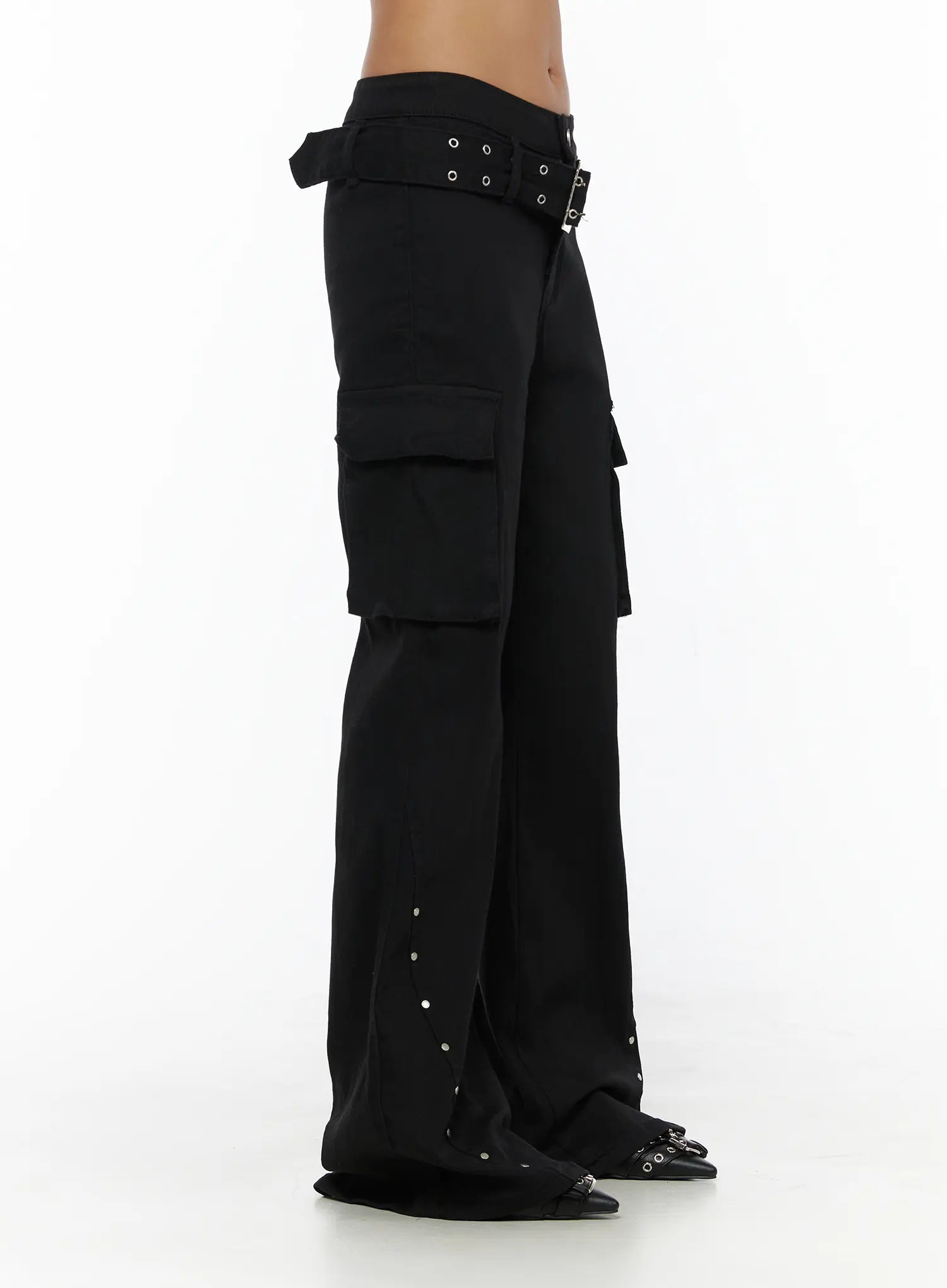 Studded Bootcut Pants CL503 Black side close-up on model showing grommet belt buckle detail, cargo pocket depth, and silver stud hem trim
