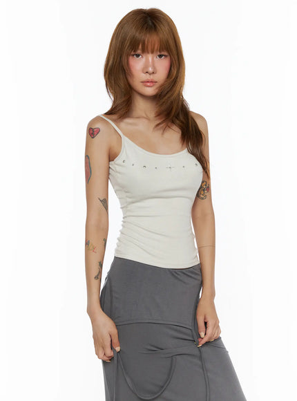 Studded Detail Tank Top CL503 Beige front shot on model, spaghetti strap ribbed cami, silver cross and stud embellishments at neckline, relaxed standing pose