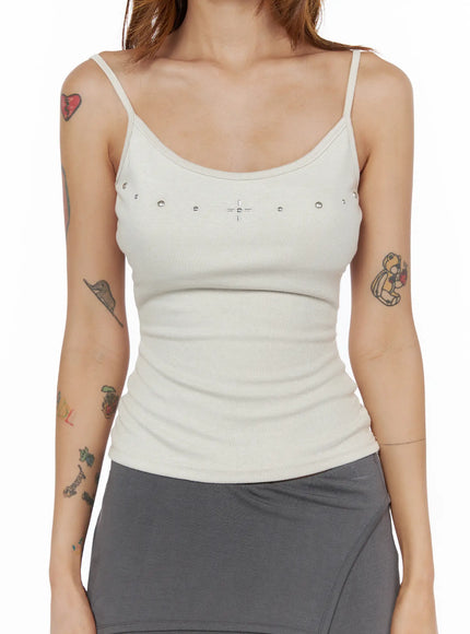 Studded Detail Tank Top CL503 Beige close-up front shot on model, silver ball studs and cross charm along chest neckline, ribbed knit fabric detail