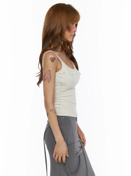 Studded Detail Tank Top CL503 Beige left side shot on model, spaghetti strap silhouette, ribbed knit texture, scoop neckline with silver stud row visible