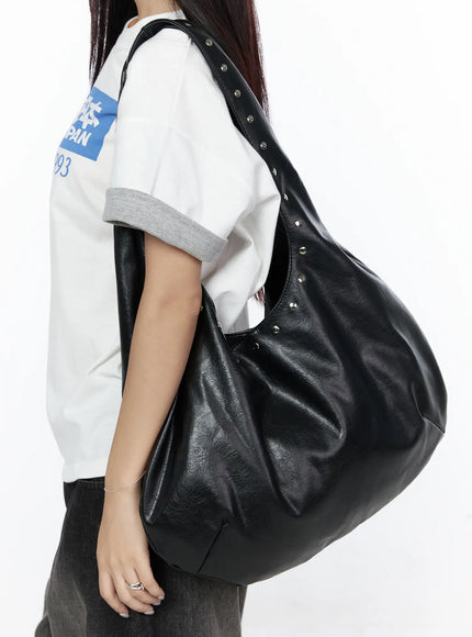 LEWKIN Studded Large Hobo Bag CL527 Black side view on model wearing white graphic tee and dark pants, slouchy faux leather shoulder bag with silver studs