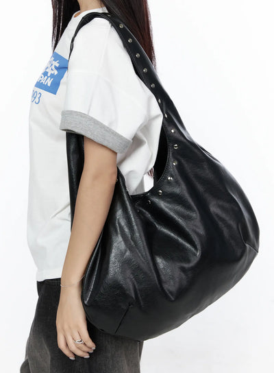 LEWKIN Studded Large Hobo Bag CL527 Black side view on model wearing white graphic tee and dark pants, slouchy faux leather shoulder bag with silver studs