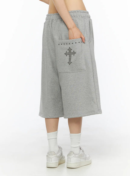 LEWKIN Studded Sweatshorts CU530 Gray S/M side view on model hand in pocket showing silver ball-stud cross patch and studded pocket trim fleece fabric