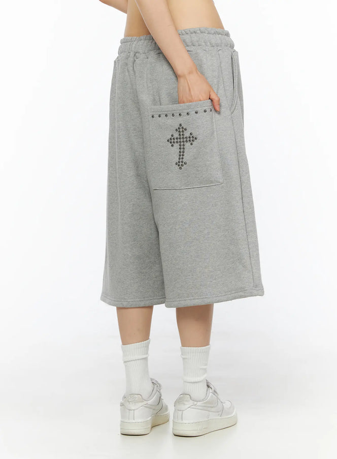 LEWKIN Studded Sweatshorts CU530 Gray S/M side view on model hand in pocket showing silver ball-stud cross patch and studded pocket trim fleece fabric