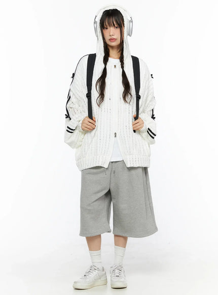Studded Sweatshorts CU530 Gray front view on model wearing white hooded knit cardigan and backpack wide-leg silhouette drawstring waist sneakers