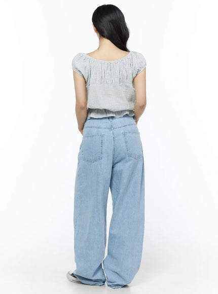 Summer Plaid Off-Shoulder Blouse IU525 Light blue back view on model showing gathered neckline, puff sleeves, and elastic ruffle hem with wide-leg jeans