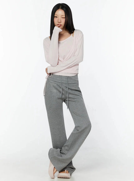 Tank And Layered Wrap Cardigan IU524 Pink full-length front shot model pensively posing hand near face showing wrap top over cami with gray wide-leg pants