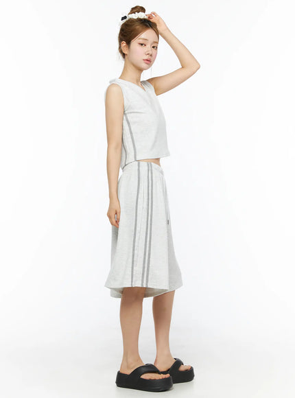 Tank Top and Track Shorts Set CL501 Light gray side full-length model shot, one hand raised to head, V-neck crop top and wide-leg stripe shorts with black platform sandals