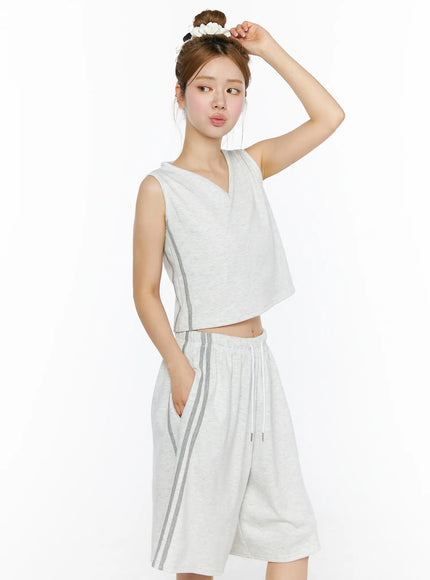 Tank Top and Track Shorts Set CL501 Light gray three-quarter front model shot, V-neck sleeveless crop top with side stripes, wide-leg shorts, hand raised to scrunchie bun