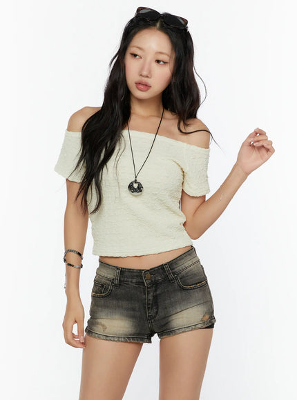 Textured Off-Shoulder Top CU529 Light yellow three-quarter front view on model with sunglasses on head pendant necklace and distressed denim shorts layered styling