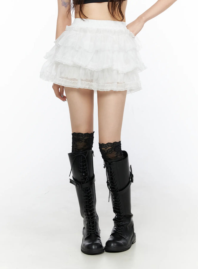 Tiered Mesh Mini Skirt CL522 White front shot on model showing multi-tier ruffled organza mini skirt with elastic waistband paired with black lace-up knee boots