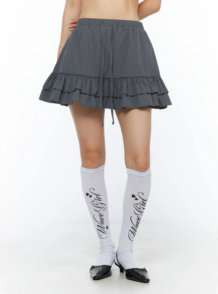 Tiered Ruffle Mini Skirt CL501 Dark gray front shot on model highlighting tiered ruffle skirt with drawstring waist and white knee socks styling