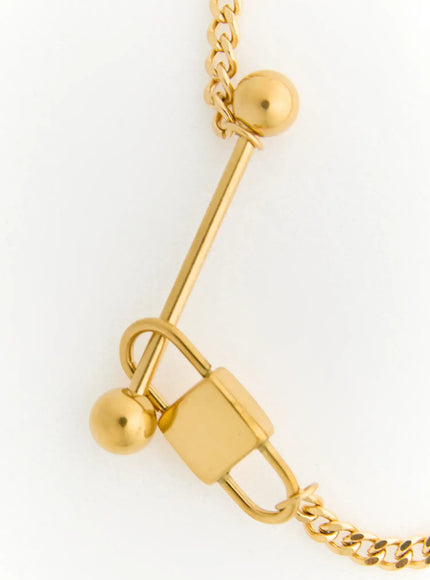Titan Bar Necklace IL522 gold detail close-up showing bar pendant with dual ball tips, safety-pin clasp mechanism on white background