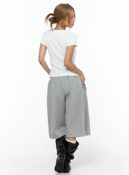 Track Bermuda Shorts CU523 Gray full back view on model in white tee and black knee boots, showing rear silhouette and wide-leg fleece construction
