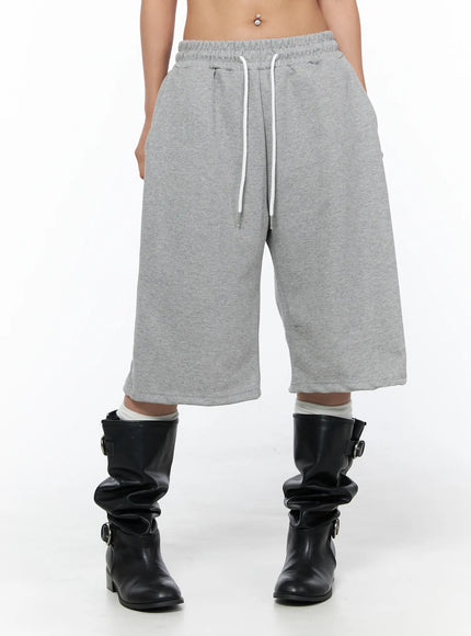 Track Bermuda Shorts CU523 Gray front view close-up on model with elastic drawstring waist, wide-leg bermuda cut, heathered fleece fabric, black boots