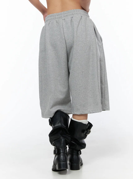 Track Bermuda Shorts CU523 Gray back close-up on model showing elastic waistband, rear pleats, and wide voluminous leg opening in heathered fleece