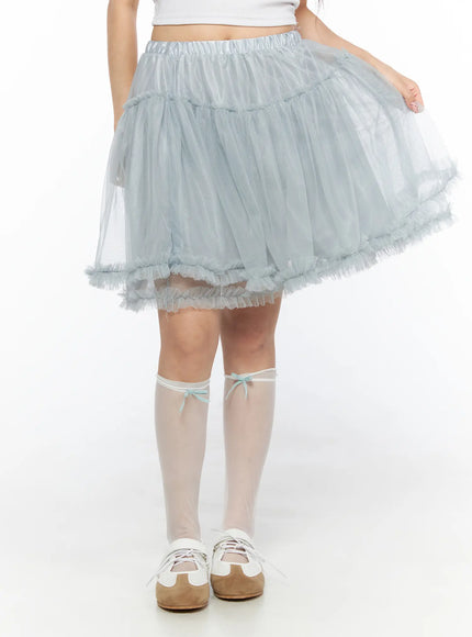 Tulle Frill Hem Midi Skirt CL514 Light blue front detail shot on model lifting skirt hem, showing voluminous sheer tulle layers and ruffle trim, with bow knee-high socks