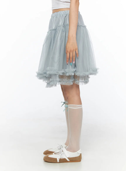 Tulle Frill Hem Midi Skirt CL514 Light blue side shot on model standing, elastic satin waistband and tiered sheer tulle panels with frilled hem detail