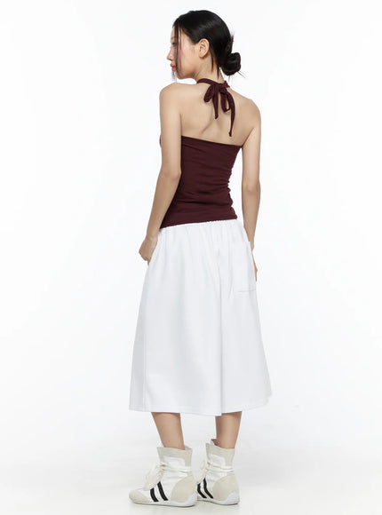 Twist Halter Top CL524 Dark red back view on model showing open back and halter neck tie knot at nape styled with white wide-leg pants and white sneakers