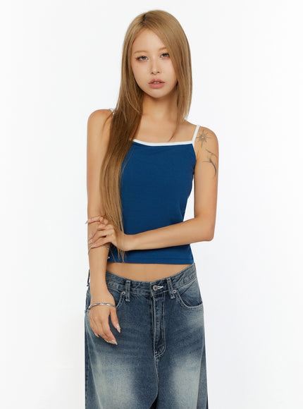 Two-Tone Cami Top IL524 Blue front model half-body shot arms crossed showing cropped ribbed knit silhouette white contrast straps and fitted waist paired with denim