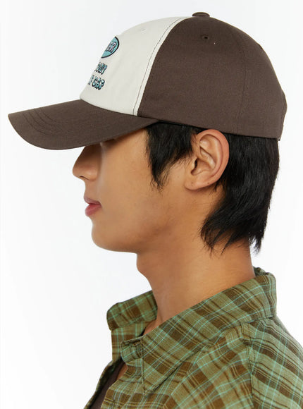 Two-Tone Graphic Cap IL515 Dark brown side model shot, male model in pure profile facing right showing structured brim and curved cap silhouette